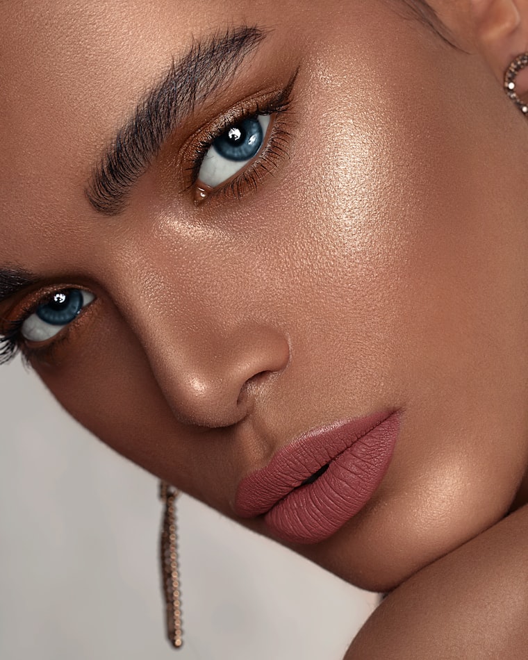 Close-up of a bronzed glowing look with a soft nude lip