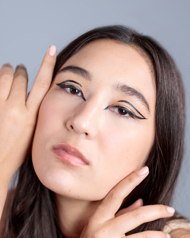 Graphic winged eyeliner paired with a nude lip
